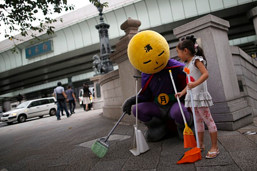 Siêu anh hùng chống xả rác Mangetsu-man tuần tra trên đường phố Tokyo và nhắc nhở các bạn nhỏ giữ vệ sinh chung. Ảnh: Issei Kato/Reuters.