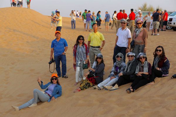 Mặc đồ dài tay và mang kính râm khi đi trên sa mạc ở Du Bai